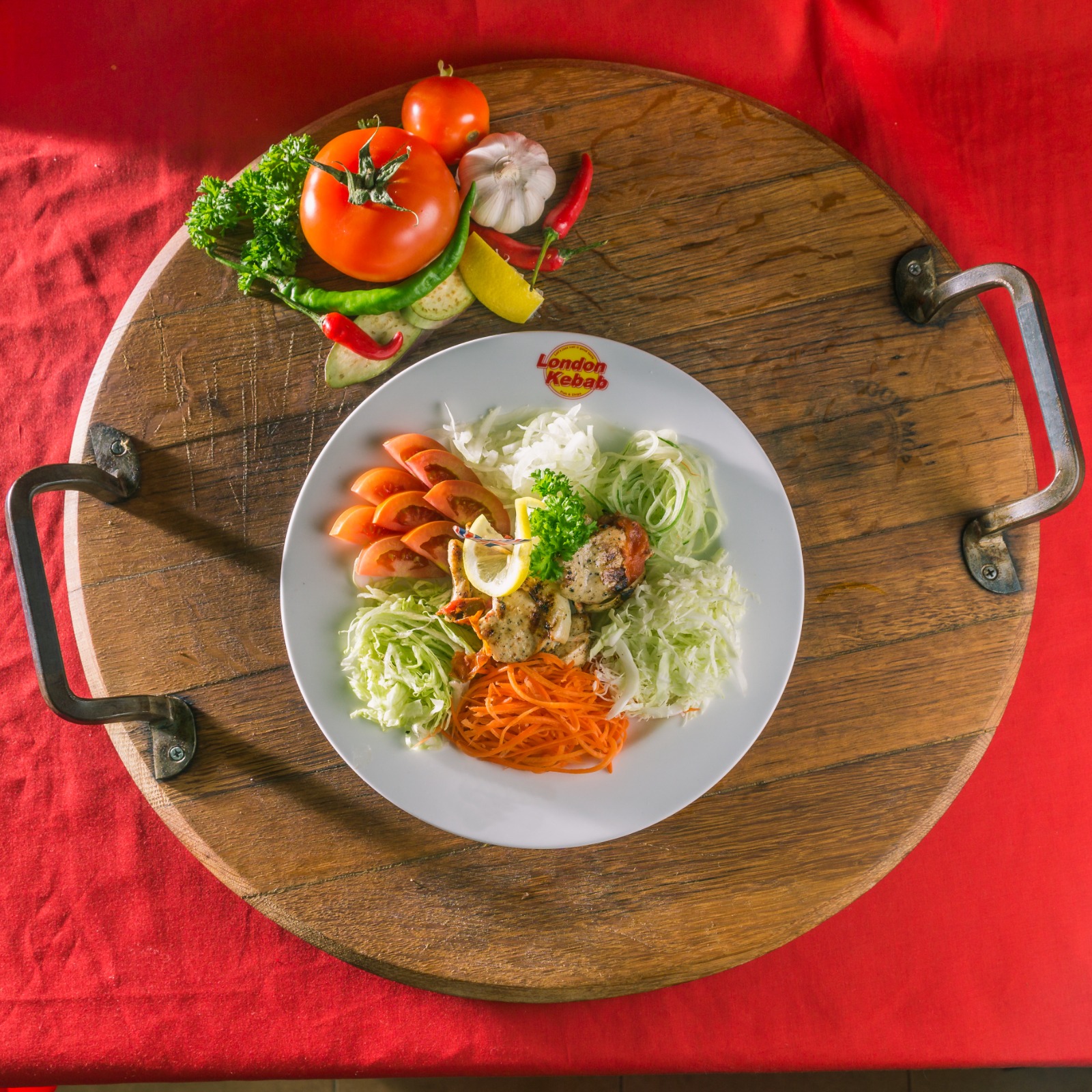 Grilled chicken with fresh salad and vegetables on a wooden board